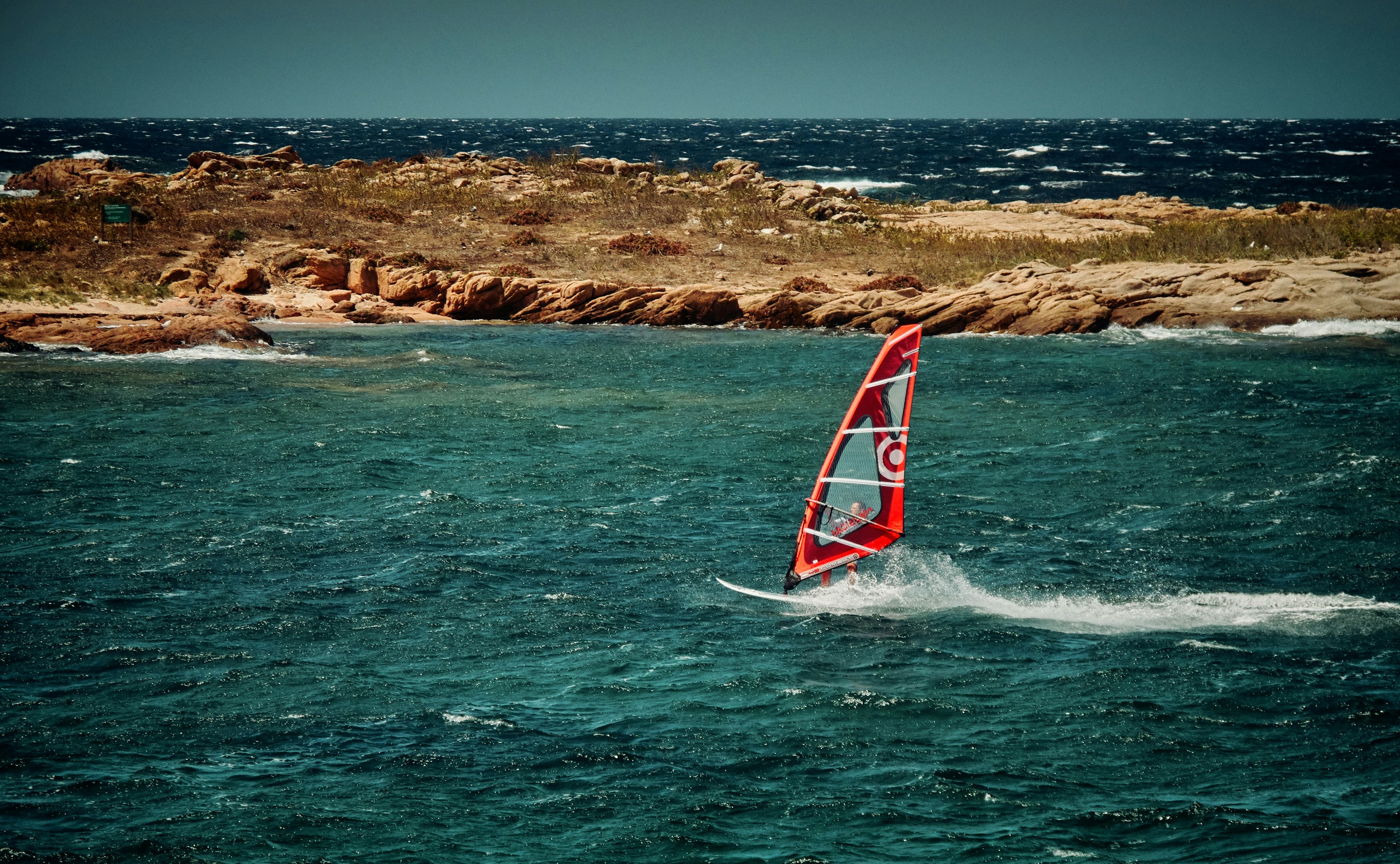 red sailing boat under blue sky